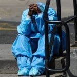 Health care worker rests outside of hospital