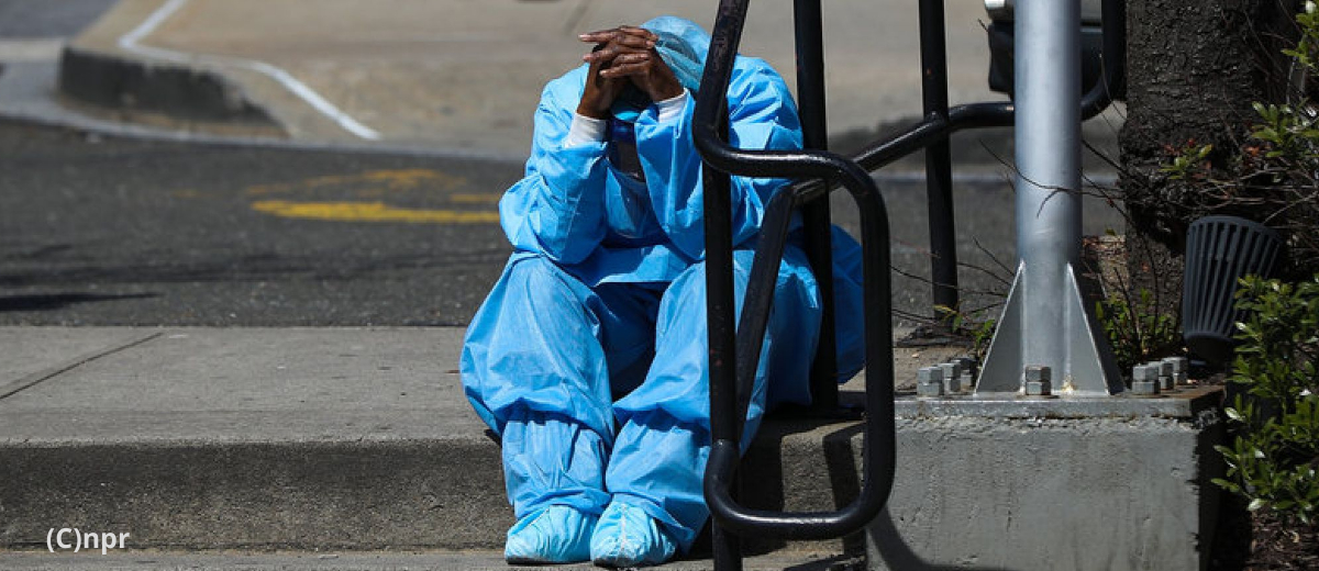 Health care worker rests outside of hospital