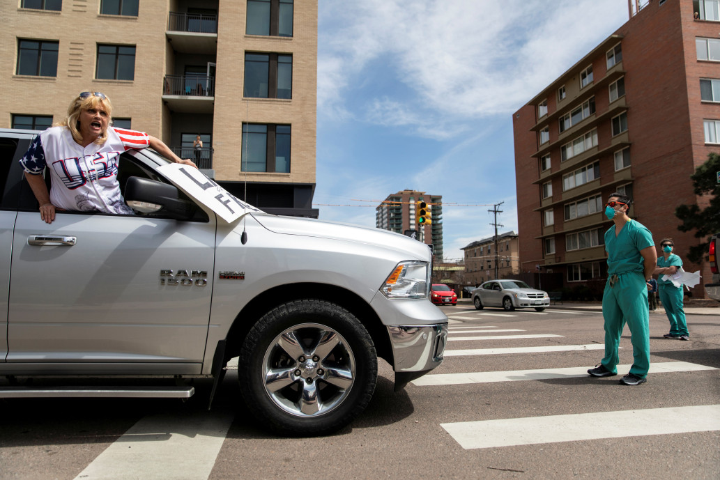 Health care worker blocks a protester's vehicle