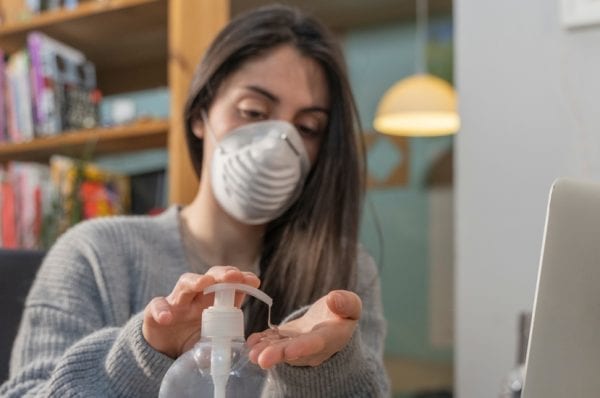 Business woman working from home wearing protective mask