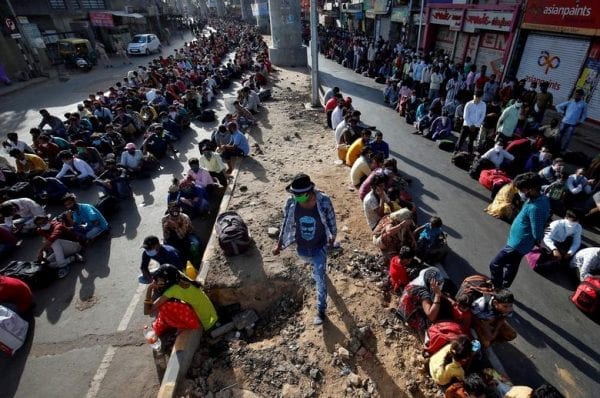Stranded migrant workers rest while on a journey back home amid the lockdown