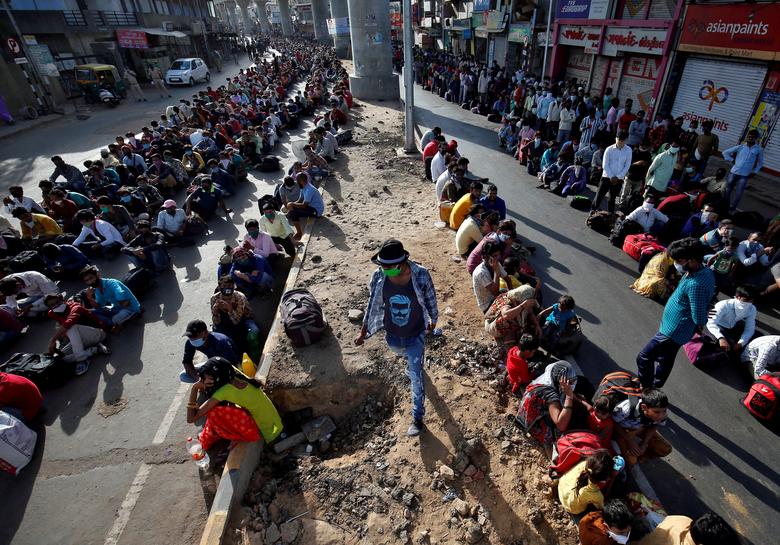 Stranded migrant workers rest while on a journey back home amid the lockdown