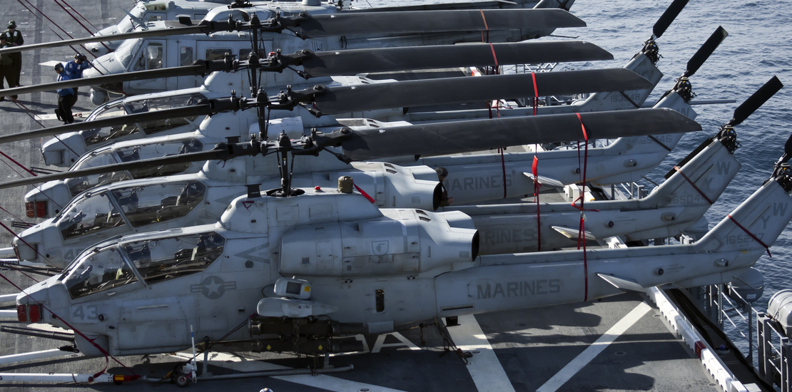 U.S. Marine Corps Huey and Cobra Helicopters sit onboard the USS Peleliu