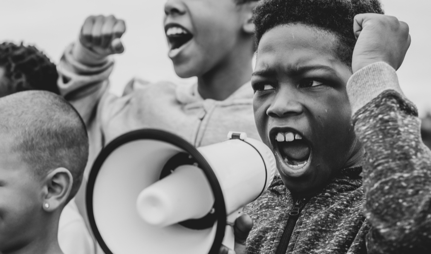 Young boy shouting on a megaphone in a protest