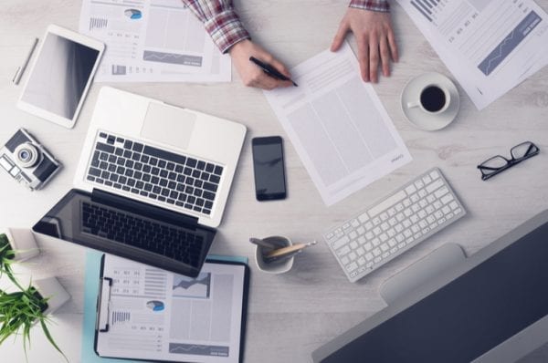 Businessman working at office desk and signing a document,