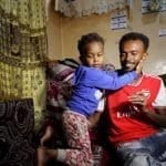 Somali refugee Bader Abdullah Hassan sits with his son, Muhammad, at their house in Sanaa, Yemen