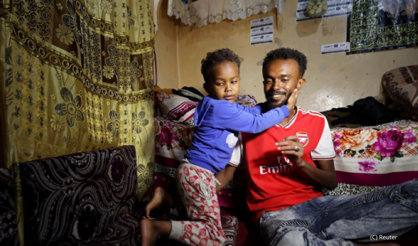 Somali refugee Bader Abdullah Hassan sits with his son, Muhammad, at their house in Sanaa, Yemen